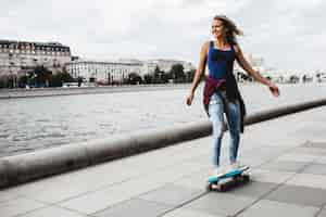 Free photo beautiful blonde skateboard on the promenade