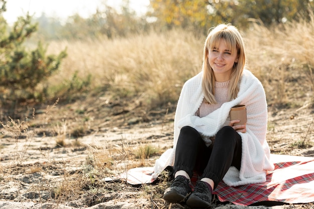 Beautiful blonde woman covering with a blanket