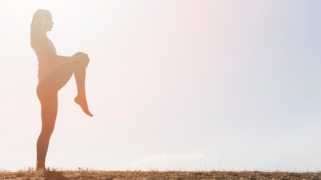 Bella donna bionda che fa yoga all'aperto