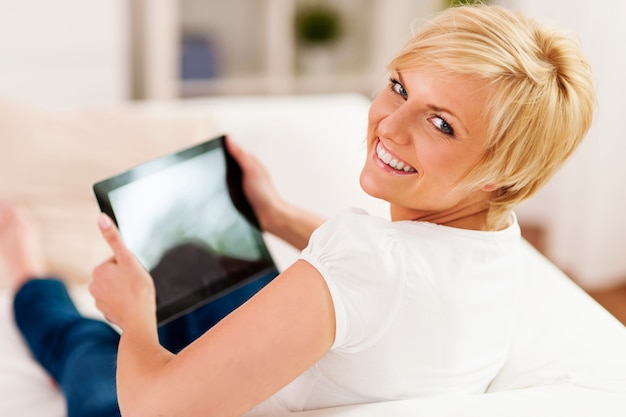 Beautiful blonde woman holding digital tablet in hands