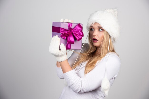 Beautiful blonde woman looking at her gift.