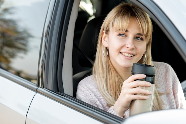 Beautiful blonde woman sitting in car