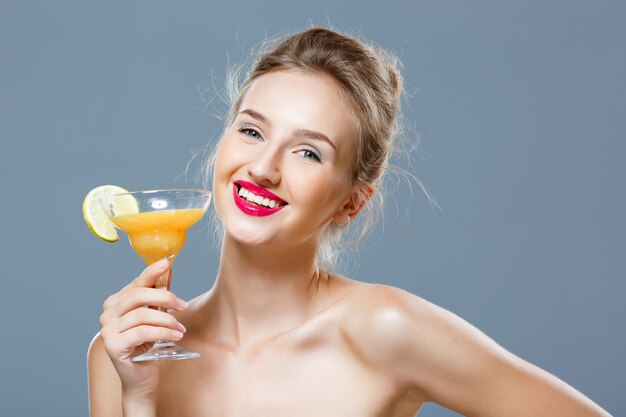 Beautiful blonde woman smiling, holding cocktail