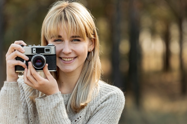 Beautiful blonde woman using a vintage camera