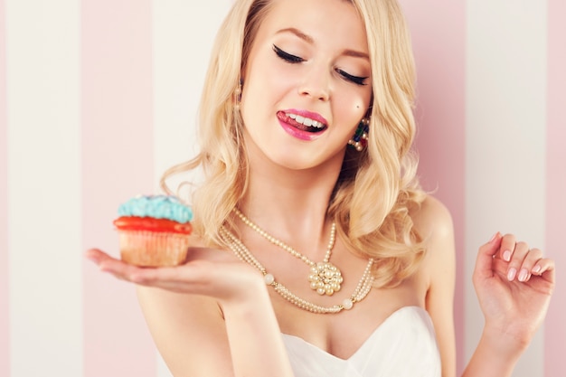 Free photo beautiful blonde woman with blue muffin