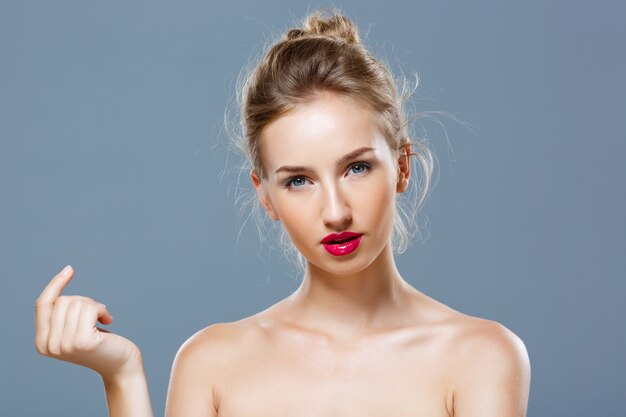 Foto gratuita bella donna bionda con la posa luminosa di trucco