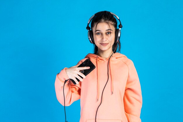 Beautiful blueeyed girl wearing headphones and looking at the camera