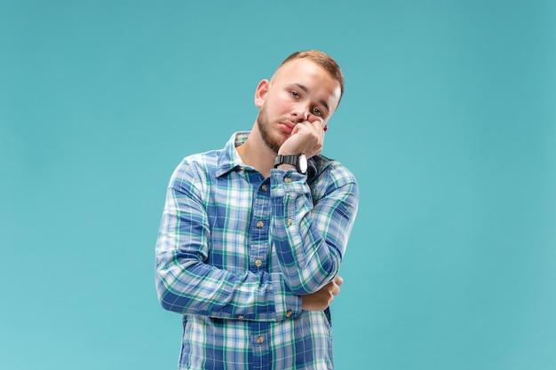 Beautiful bored man bored isolated on blue wall