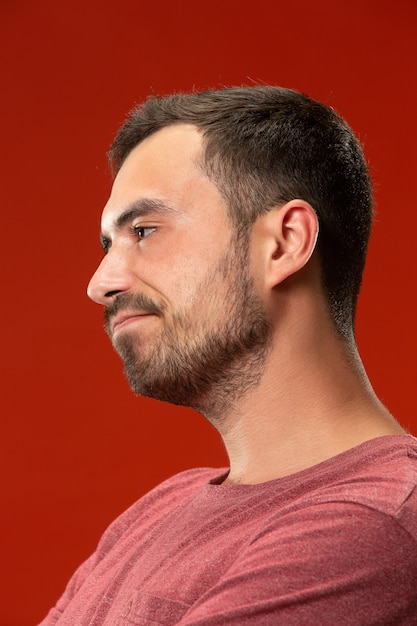 Beautiful bored man bored isolated on red wall