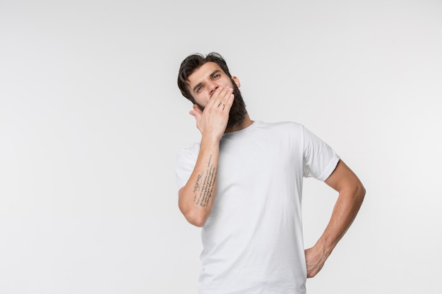 Beautiful bored man bored isolated on white wall