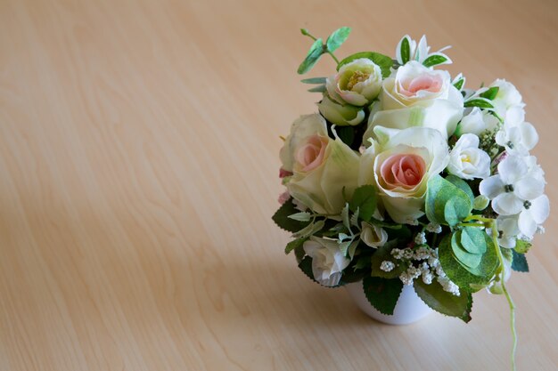 Beautiful bouquet of artificial  flowers in on wooden table