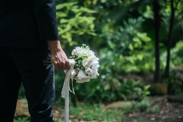 Beautiful bouquet in the hands of the groom for bride.