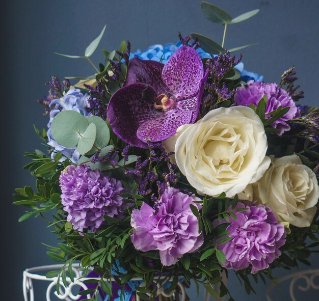 Beautiful bouquet of lilacs and roses standing in a rustic hence vase