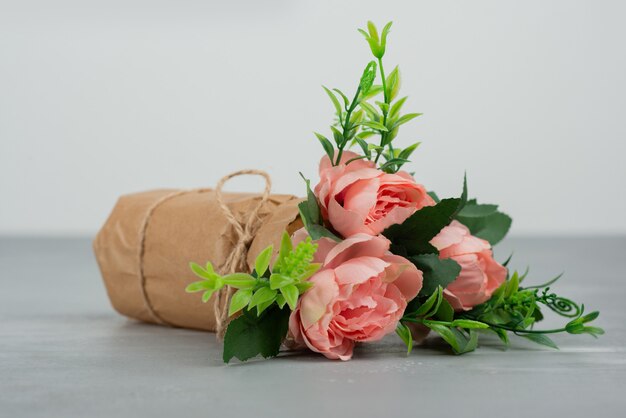 Красивый букет розовых роз на серой поверхности