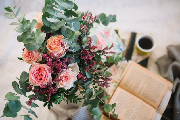 Free photo beautiful bouquet standing near books an coffee