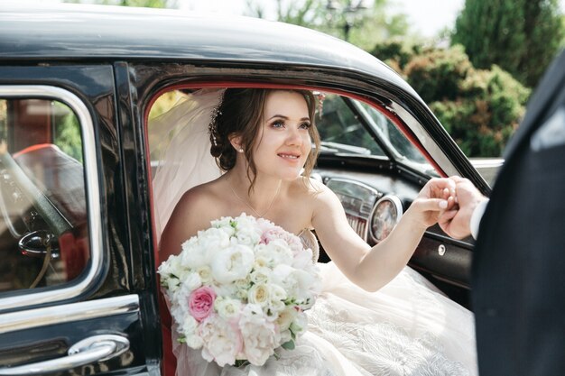 The beautiful bride comes out of the car