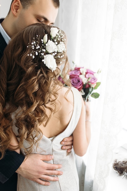 Foto gratuita la bella sposa e lo sposo abbracciando nella stanza