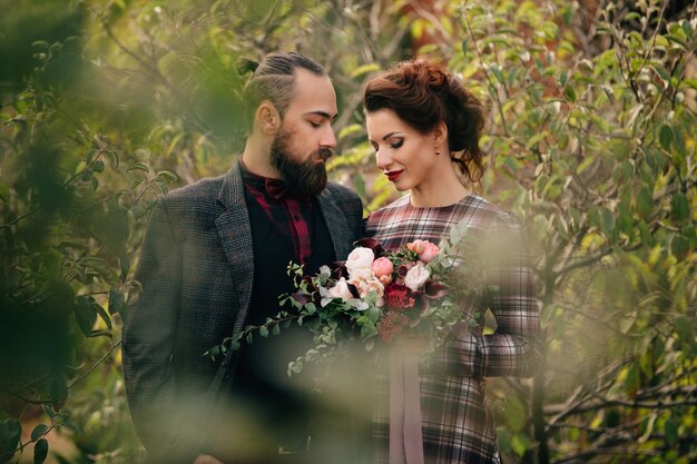 Beautiful bride and groom walk in the garden after the wedding ceremony