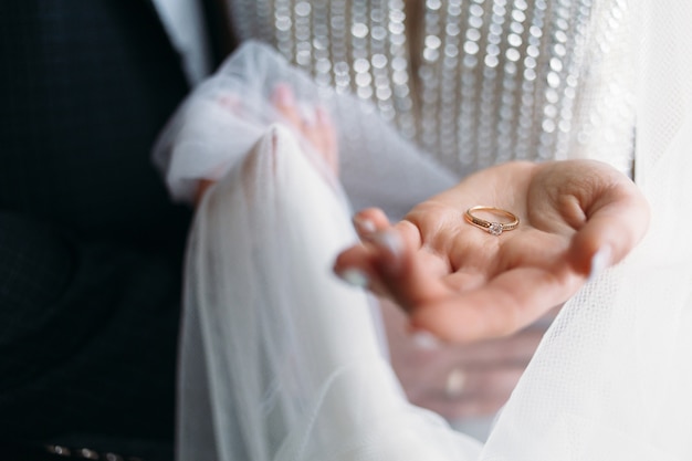 The beautiful bride holds a wedding ring