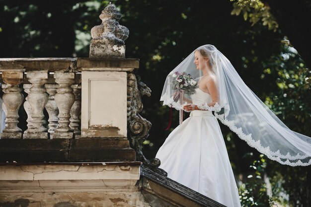 The beautiful bride stands on the chair