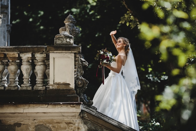 The beautiful bride stands on the chairs