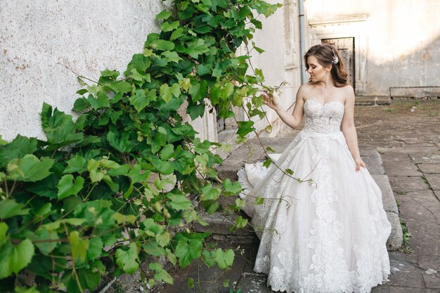 Beautiful bride walks around the old building