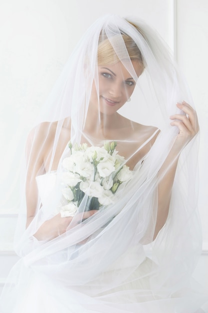 Foto gratuita bella sposa con velo e bouquet