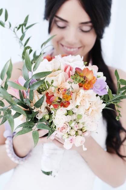 꽃의 꽃다발을 들고 웨딩 드레스에 아름 다운 신부 여자