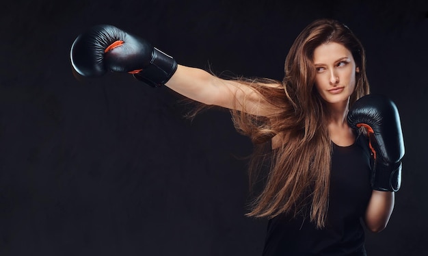 ボクシングの練習中の美しいブルネットの女性ボクサー、深刻な集中顔のプロセスに焦点を当てています。