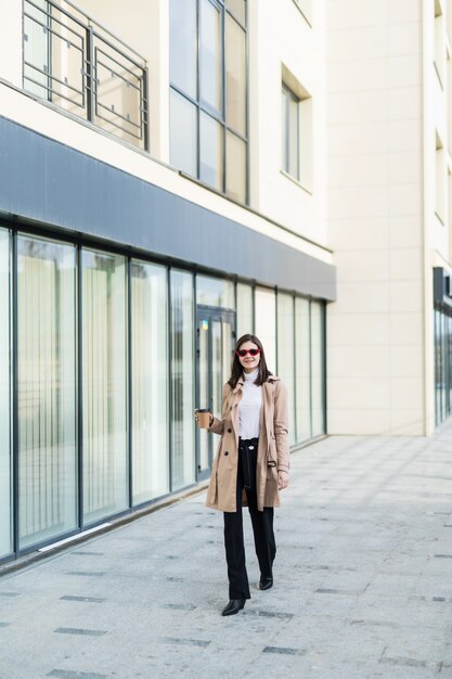 Beautiful brunette girl walking down the street in funny sunglasses