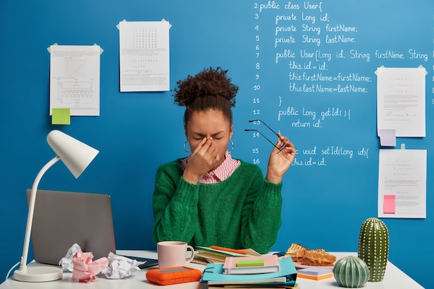 Foto gratuita bella donna castana che rimane nel suo posto di lavoro