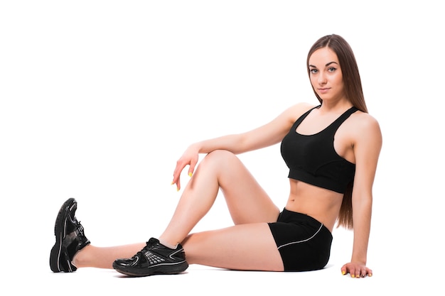 Beautiful brunette woman stretching her legs, warm up isolated on white background