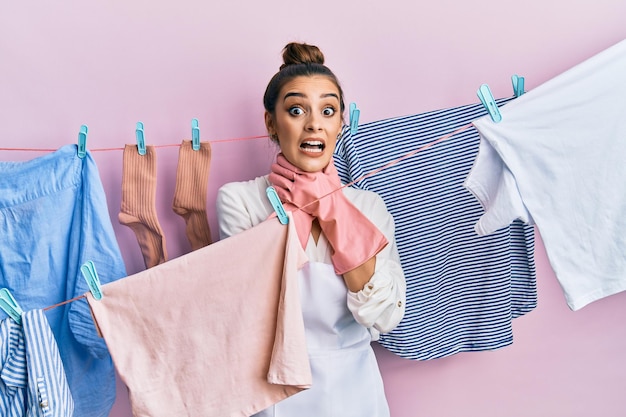 Free photo beautiful brunette young woman washing clothes at clothesline shouting and suffocate because painful strangle. health problem. asphyxiate and suicide concept.