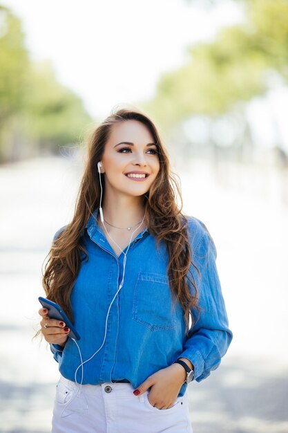 ドレスを着て、通りを歩いている美しいブルネットの若い女性