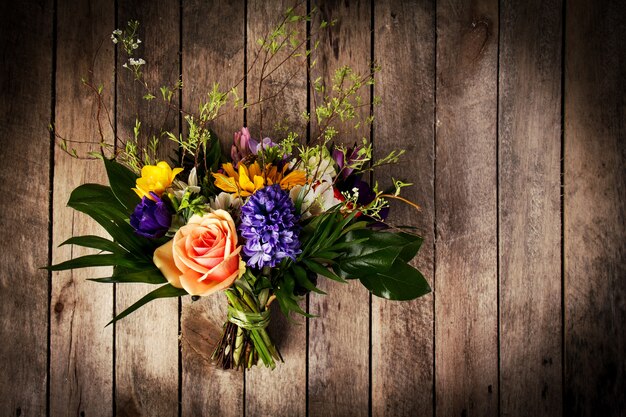 Beautiful bunch of flowers on wooden background. Horizontal. View from above.