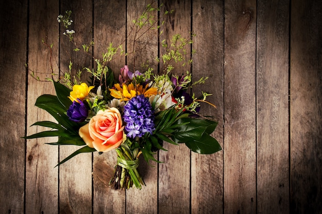 Beautiful bunch of flowers on wooden background. Horizontal. View from above.