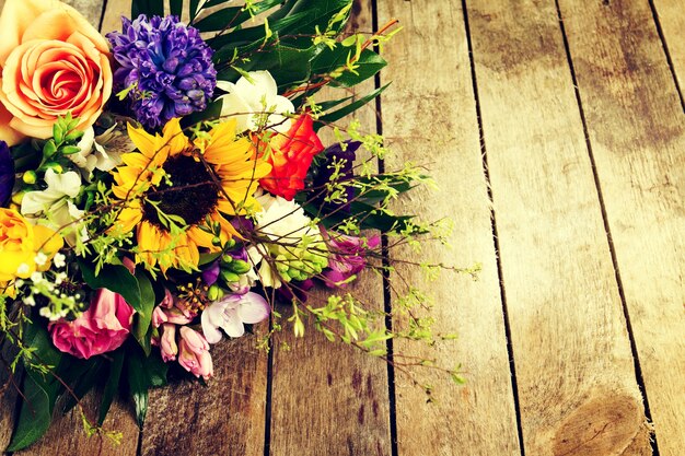 Beautiful bunch of flowers on wooden background. Horizontal. View from above.