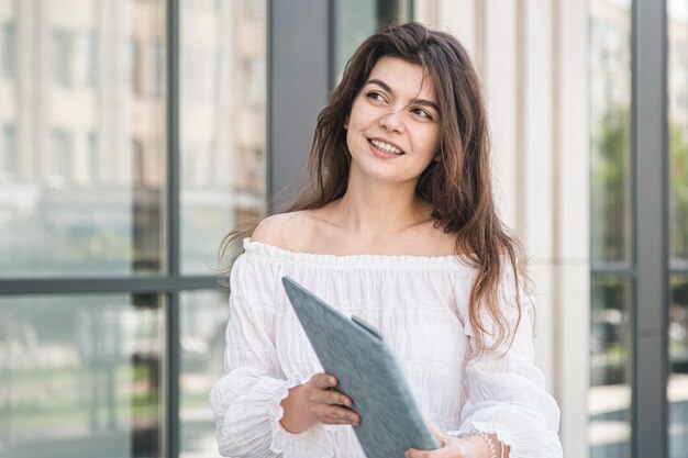 Beautiful business young woman with laptop outdoors