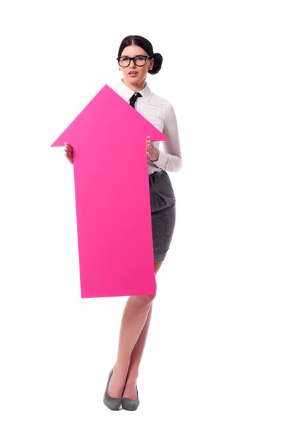 Beautiful businesswoman holding pink arrow sign