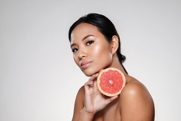 Beautiful calm woman showing grapefruit slice