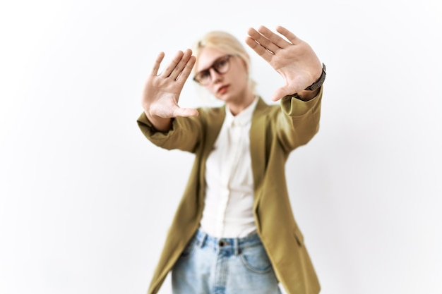 Beautiful caucasian business woman standing over isolated background doing frame using hands palms and fingers, camera perspective