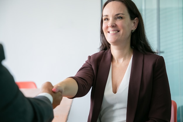 Free photo beautiful caucasian businesswoman handshaking and smiling