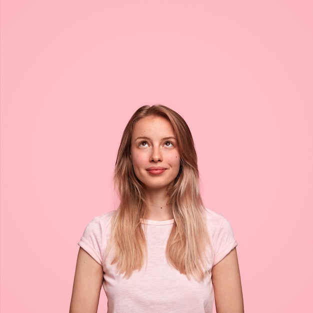 Beautiful Caucasian female looks happily upwards