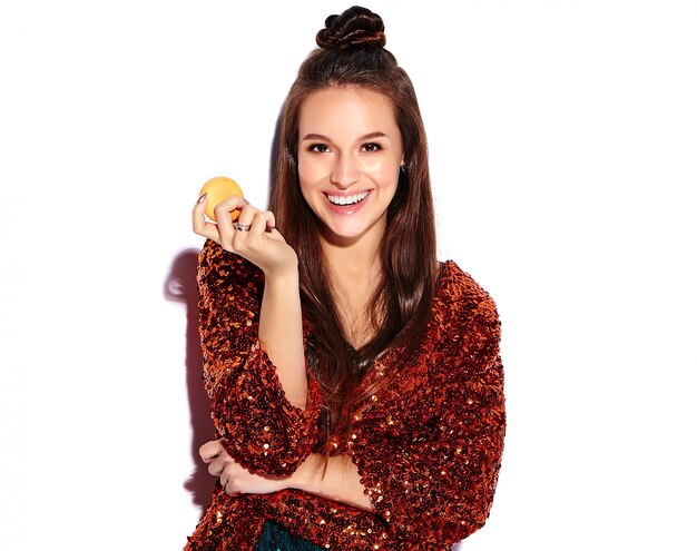 Beautiful caucasian smiling hipster brunette woman model in bright shinny reflecting summer stylish jacket and green dress isolated . Eating french macaroon