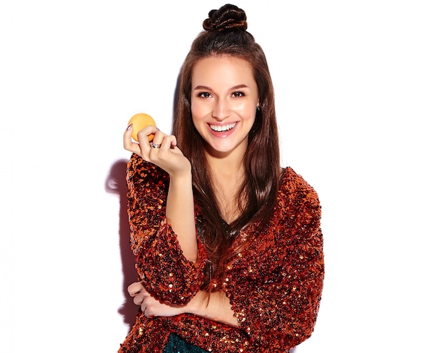 Beautiful caucasian smiling hipster brunette woman model in bright shinny reflecting summer stylish jacket and green dress isolated . Eating french macaroon