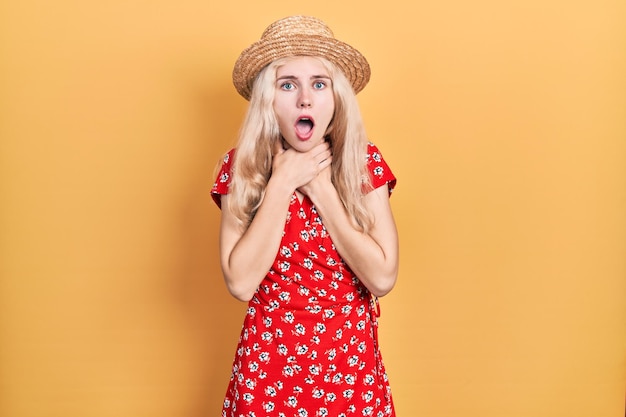 Free photo beautiful caucasian woman with blond hair wearing summer hat shouting and suffocate because painful strangle health problem asphyxiate and suicide concept