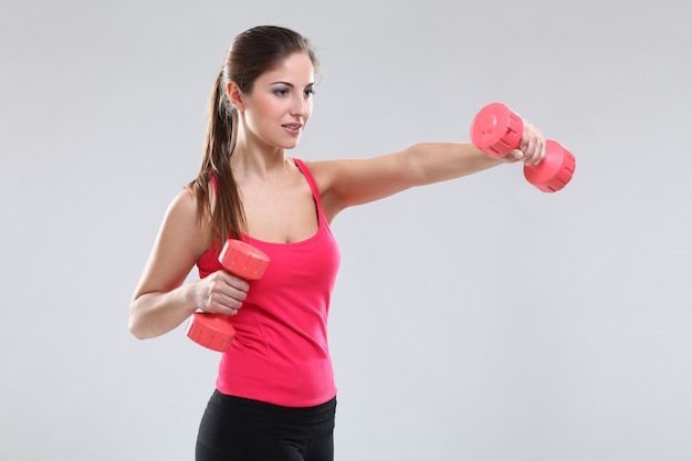 Beautiful caucasian woman with dumbbells