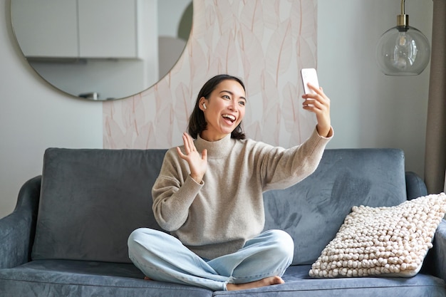 美しいおしゃべりな女の子のビデオ チャット携帯電話 c に笑みを浮かべて selfie を取ってスマート フォンでビデオを作る