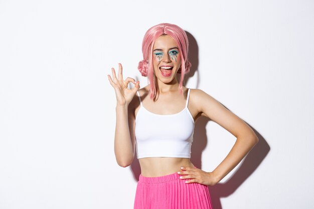 Beautiful cheeky girl in halloween costume and pink wig