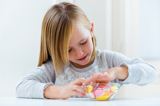 お菓子を家で食べる美しい子供。